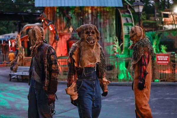 Rotten pumpkin characters walk around Fright Fest scare zone The Rotted Ones at Six Flags Over Georgia. (Natrice Miller/AJC)