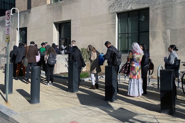 Hundreds of employees wait in line wrapped around the outside of the Health and Human Services headquarters building, Tuesday morning, April 1, 2025 in Washington. (AP Photo/Amanda Seitz)