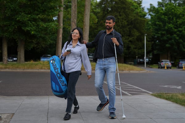 Blind tennis champion Naqi Rizvi and his wife Zara attend a visually impaired tennis training session in London, Tuesday, May 20, 2025. (AP Photo/Kin Cheung)