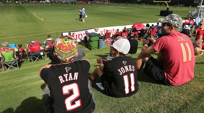 Jim Caldwell and his sons Judson (left) and Nathan watch the first day of training camp from the hill.