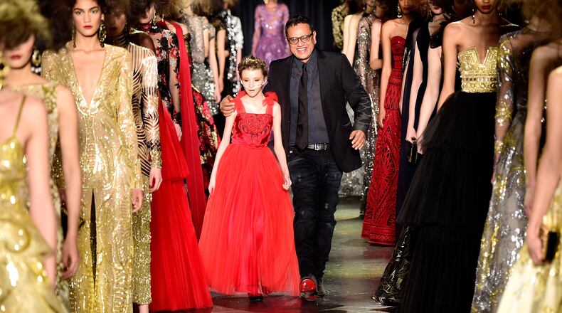 NEW YORK, NY - FEBRUARY 17: From Make-A-Wish Foundation, Trinity Faith Moran (L) and designer Naeem Khan greet the audience from the runway at Naeem Khan Fall 2016 during New York Fashion Week: The Shows at The Arc, Skylight at Moynihan Station on February 17, 2016 in New York City. (Photo by Frazer Harrison/Getty Images for NYFW: The Shows)