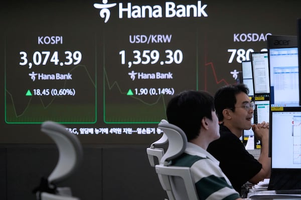 Currency traders watch monitors near a screen showing the Korea Composite Stock Price Index (KOSPI), top left, and the foreign exchange rate between U.S. dollar and South Korean won, top center, at the foreign exchange dealing room of the KEB Hana Bank headquarters in Seoul, South Korea, Monday, June 30, 2025. (AP Photo/Ahn Young-joon)