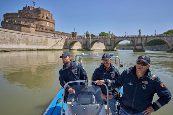 Italian police officers on a dinghy boat patrol for security the Tiber river near the Vatican, with the Sant'Angelo castle in the background, Tuesday, April 22, 2025. (AP Photo/Bernat Armangue)
