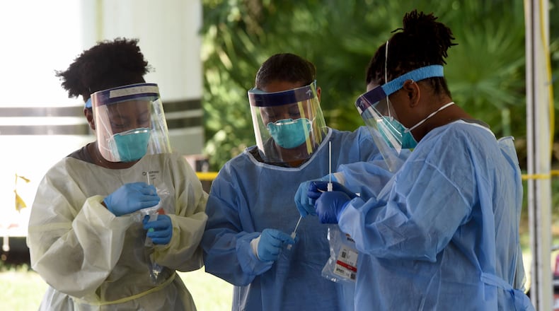 (From left to right) Jacqueline Jones, LPN, Sasha Stewart, RN, and Jesslyn Lewis, RN, secure COVID-19 tests outside the Glynn County Health Department in Brunswick. Ryon Horne/RHORNE@AJC.COM