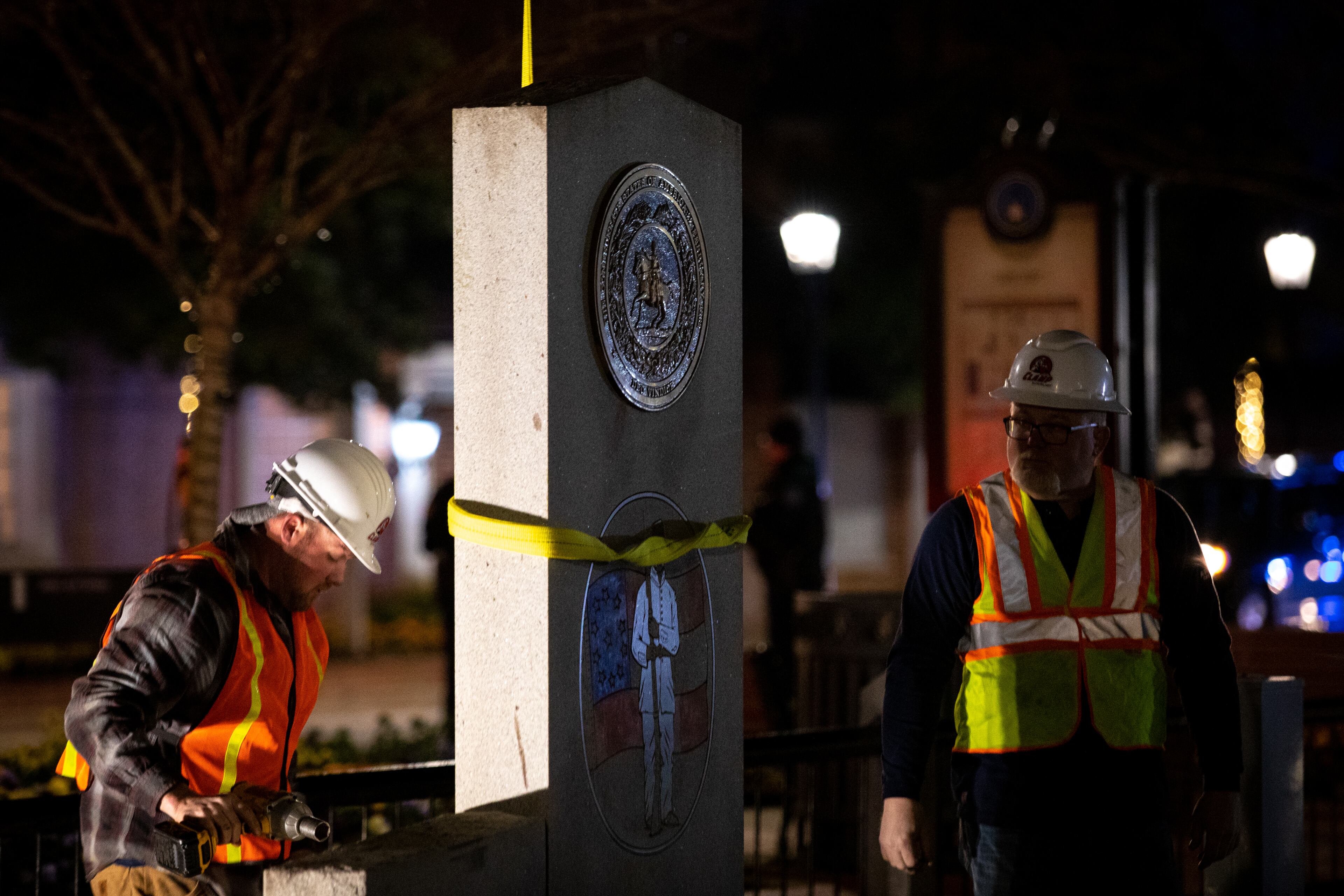 A crew works to remove a Confederate monument from its place on the grounds of the Gwinnett Historic Courthouse in Lawrenceville, Ga., on Thursday, Feb. 4, 2021. (Casey Sykes for the AJC)