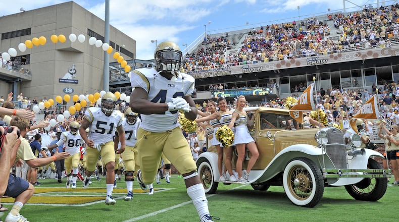 Georgia Tech’s Ramblin Wreck and cheerleaders lead the football on the field to start the before the start of the Georgia Tech season opener against the Wofford Terriers at Bobby Dodd Stadium on Saturday, August 30, 2014. HYOSUB SHIN / HSHIN@AJC.COM
