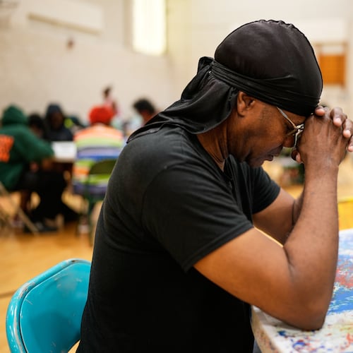 A person prays before receiving a free boxed lunch at City Life Center in Gary, Ind., Thursday, Aug. 20, 2026, more than a week after a deadly storm passed through the area. (AP Photo/Nam Y. Huh)