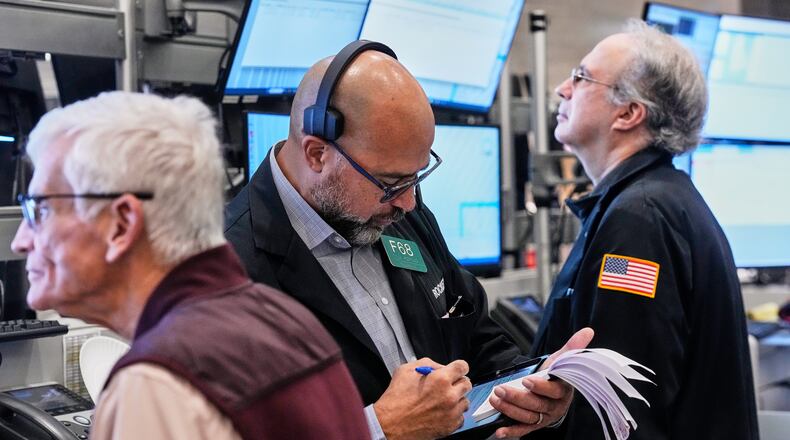 Options trader Steven Rodriguez, center, works on the floor of the New York Stock Exchange, Monday, Oct. 20, 2025. (AP Photo/Richard Drew)