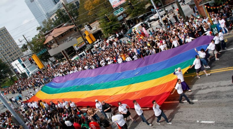 Unfurling a symbol of pride: Marchers in Pride 2011 carry a massive rainbow flag through Midtown Atlanta. Credit: Henry Etsitty