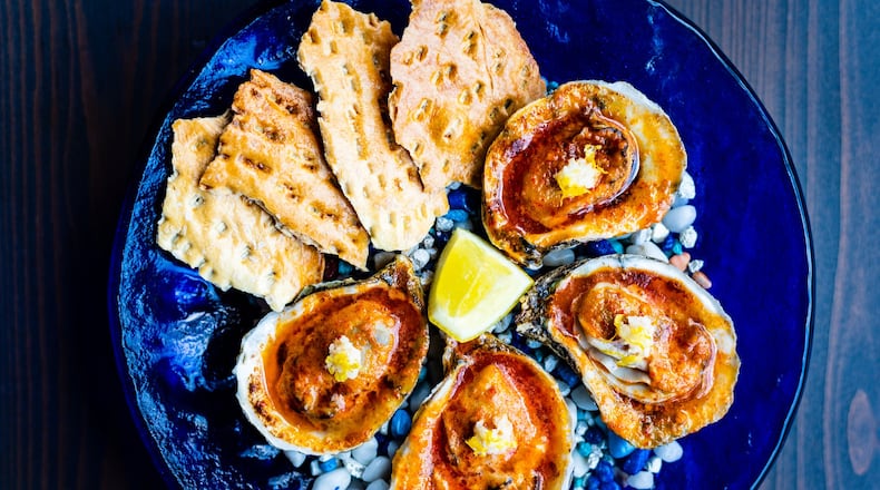 Roasted oysters with Calabrian chiles and saltines at Cold Beer. CONTRIBUTED BY HENRI HOLLIS