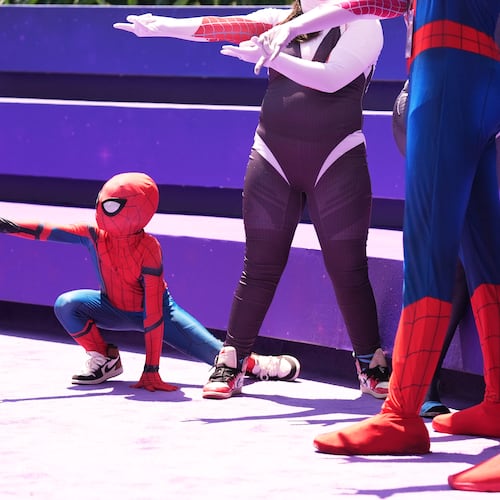 Daniel Delgado, 6, of Victorville, Calif., joins a photo op for cosplayers dressed as "Spider-Man" during D23: The Ultimate Disney Fan Event on Friday, Aug. 14, 2026, at the Anaheim Convention Center in Anaheim, Calif. (AP Photo/Chris Pizzello)
