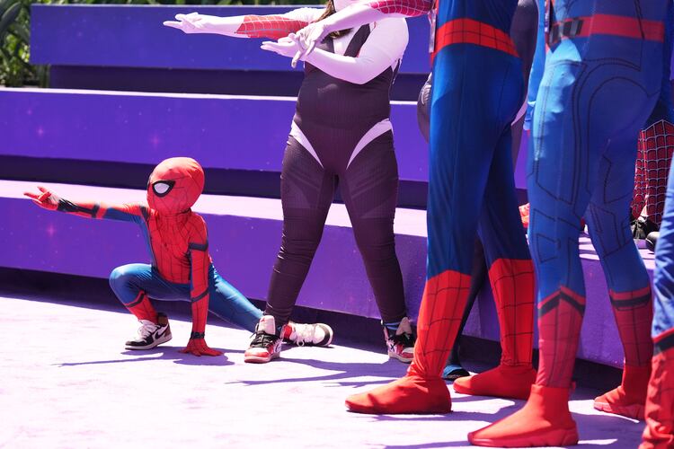 Daniel Delgado, 6, of Victorville, Calif., joins a photo op for cosplayers dressed as "Spider-Man" during D23: The Ultimate Disney Fan Event on Friday, Aug. 14, 2026, at the Anaheim Convention Center in Anaheim, Calif. (Chris Pizzello/AP)