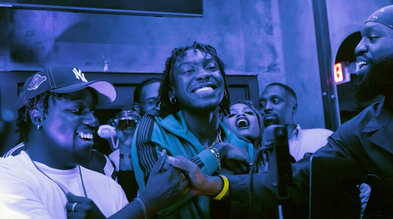 Atlanta R&B artist Chase Shakur (middle) celebrates the release of his album, "Wonderlove," by interacting with fans and taking to the mic during an album release party at the Enjoyment Room in Midtown. The album is Shakur's major-label debut. (Christina Matacotta for the AJC)