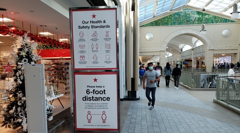 Retailers, such as Macy's at Lenox Square mall in Atlanta, are encouraging shoppers to comply with pandemic-related safety measures amid the holiday shopping season. MATT KEMPNER / AJC