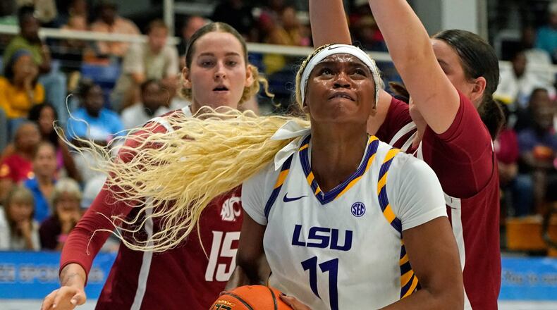 LSU guard ZaKiyah Johnson, center, drives for a shot between Washington State defenders Keandra Koorits, left, and Malia Ruud during the first quarter of their Reef Division championship game at the Paradise Jam NCAA college basketball tournament in St. Thomas, U.S. Virgin Islands, Saturday, Nov. 29, 2025. (Bill Kiser/Virgin Islands Daily News via AP)