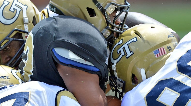 Wofford Terriers fullback Jonny Martin (center) is stopped by Georgia Tech's Shawn Green (left) and Tyler Stargel (99).