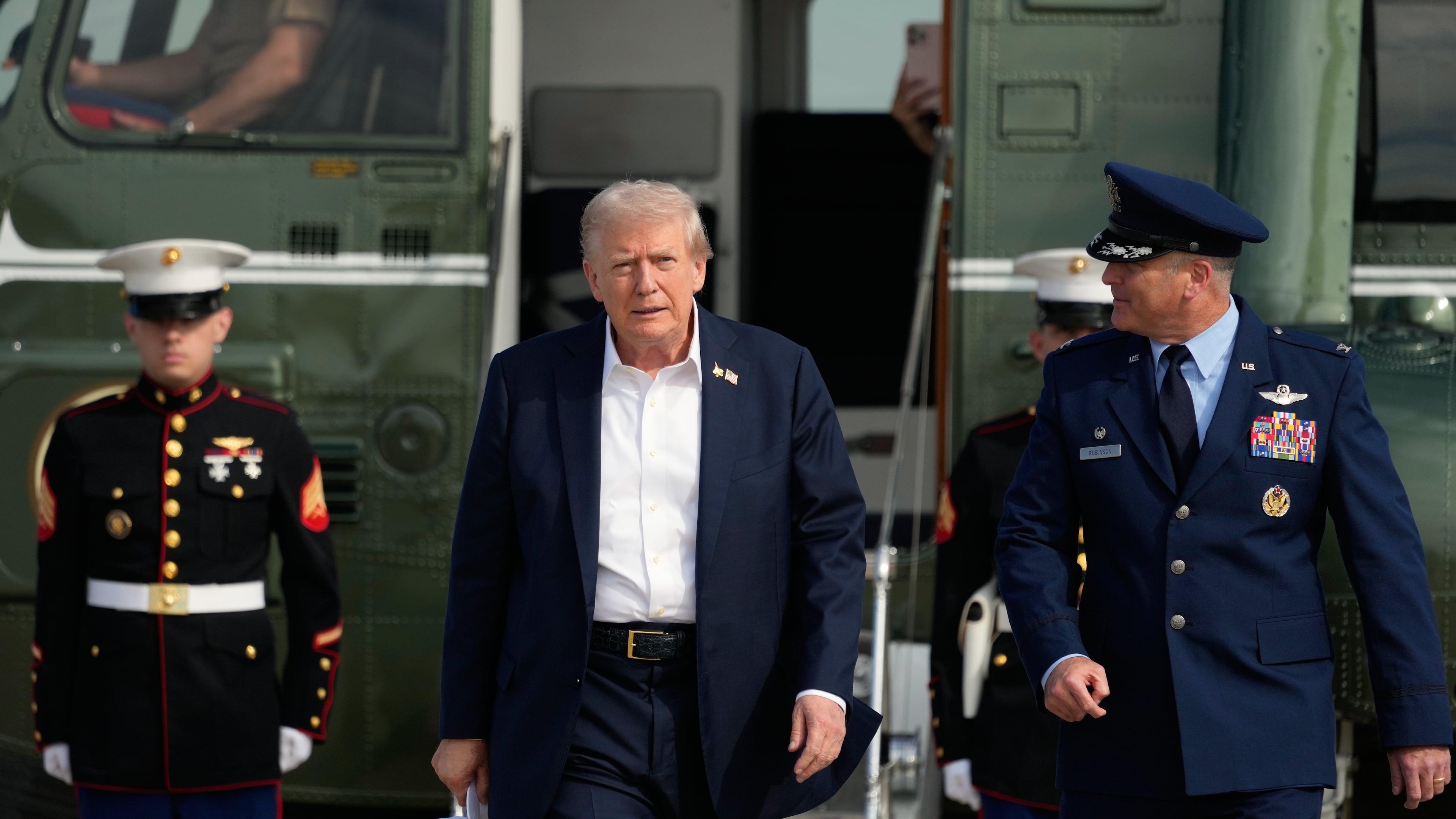 President Donald Trump, center, is escorted by Air Force Col. Christopher M. Robinson, commander of the 89th Airlift Wing, right, as he walks from Marine One to board Air Force One, Friday, Sept. 26, 2025, at Joint Base Andrews, Md. (AP Photo/Alex Brandon)
