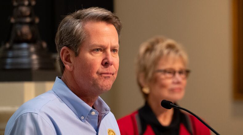 200408-Atlanta-Gov. Brian Kemp listens to a question from a journalist during a press conference Wednesday afternoon April 8, 2020 at the Georgia State Capitol as Commissioner of Public Health Dr. Kathleen Toomey listens in the background. Ben@BenGray.com for the Atlanta Journal-Constitution