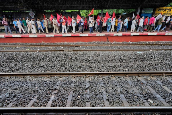 Supporters of Centre of India Trade Unions, CITU, walk in a rally on a railway station platform during a nation-wide strike to protest what they call the anti-labor and anti-poor policies of the federal government, in Kolkata, India, Wednesday, July 9, 2025. (AP Photo/Bikas Das)