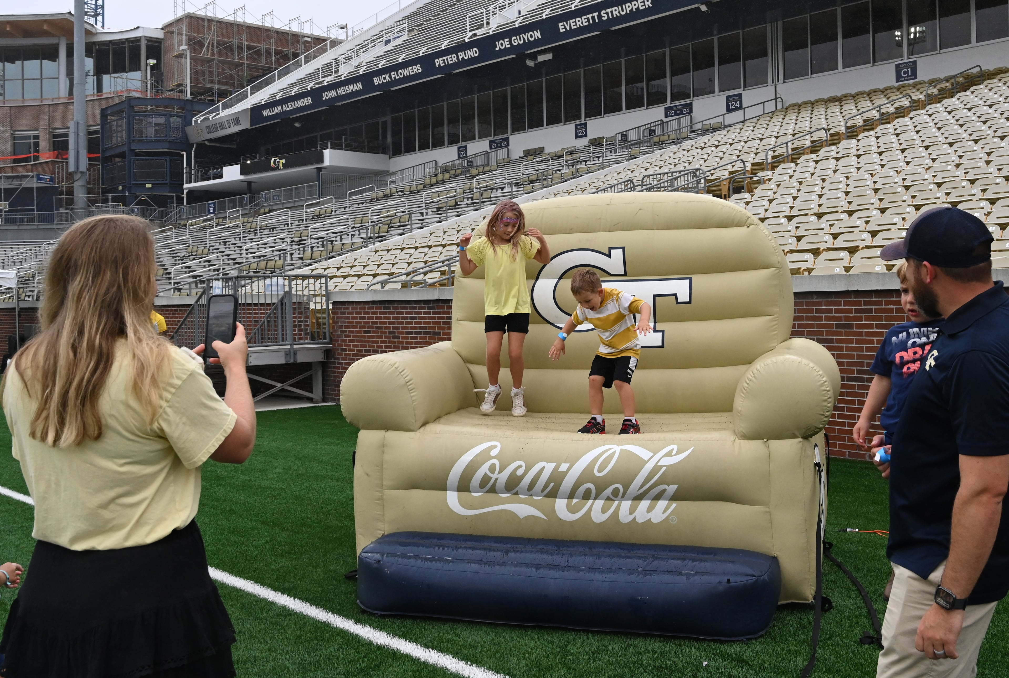 Attendees enjoy a variety of entertaining activities during the annual “First Saturday on The Flats” at Bobby Dodd Stadium, Saturday, August 2, 2025, in Atlanta. The Flats provides Tech fans with the opportunity to engage with their favorite Yellow Jackets ahead of the upcoming 2025 season. The event offers a variety of entertaining activities for the whole family, including a DJ, autograph opportunities, tailgate games and interactive experiences right on the field at Bobby Dodd Stadium. (Hyosub Shin / AJC)