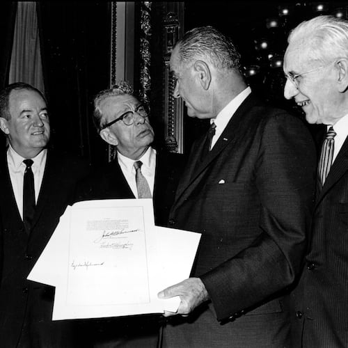 FILE - President Lyndon B. Johnson holds the signed document of the Voting Rights Act of 1965 as he chats with Sen. Everett Dirksen, R-Ill., in the President's Room in Washington, Aug. 6, 1965. Signatures that appear on the document are Johnson, left bottom; House Speaker John McCormack, upper, standing at right; and Vice President Hubert Humphrey, lower, standing second from left. Standing at far left is Sen. Mike Mansfield. (AP Photo)