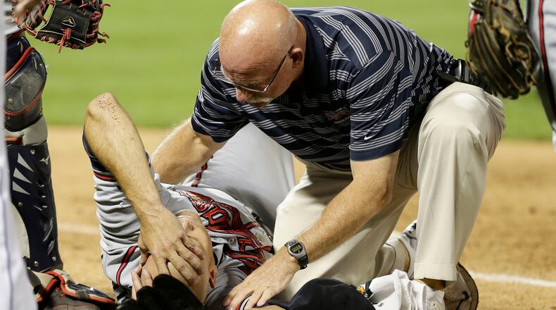 Atlanta Braves' Tim Hudson is helped by a trainer after being injured on a play at first base during the eighth inning of a baseball game against the New York Mets, Wednesday, July 24, 2013, in New York.