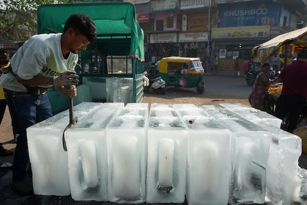 FILE - A man arranges ice blocks to sell at his stall in Ahmedabad, India, April 2, 2025. (AP Photo/Ajit Solanki, File)
