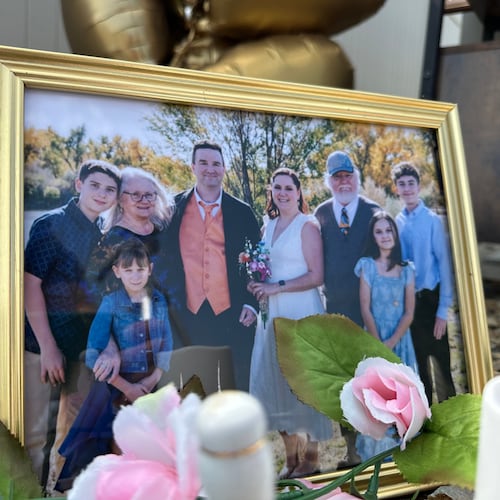 A wedding photo taken by Miranda Murdock that shows relatives who were killed in a home outside Billings, Mont., is displayed at a memorial site on Wednesday, Aug. 26, 2026. (AP Photo/Matthew Brown)