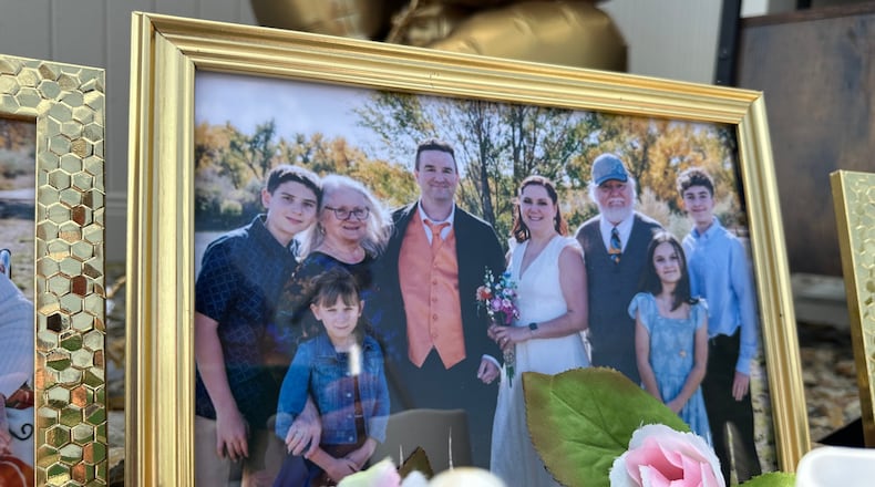 A wedding photo taken by Miranda Murdock that shows relatives who were killed in a home outside Billings, Mont., is displayed at a memorial site on Wednesday, Aug. 26, 2026. (AP Photo/Matthew Brown)