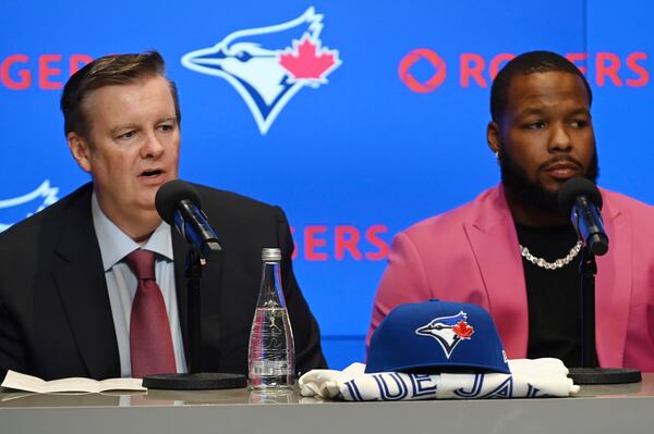 Edward S. Rogers III, chairman of the board of directors of Rogers Communications, left, and Toronto Blue Jays first baseman Vladimir Guerrero Jr. participate in a press conference in Toronto on Monday April 14, 2025. (Jon Blacker/The Canadian Press via AP)