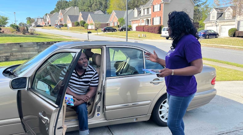 Isaac Akomeah, seated, chats about the Democratic primary in Georgia's 7th Congressional District with state Rep. Donna McLeod, one of the three candidates in the race. (Tia Mitchell/The Atlanta Journal-Constitution)