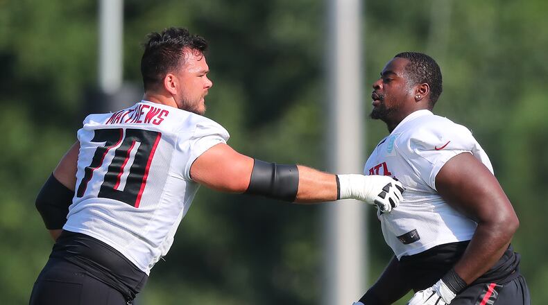 Falcons offensive lineman Jake Matthews works with rookie offensive lineman Kion Smith on the fourth day of training camp practice in Flowery Branch.   “Curtis Compton / Curtis.Compton@ajc.com”