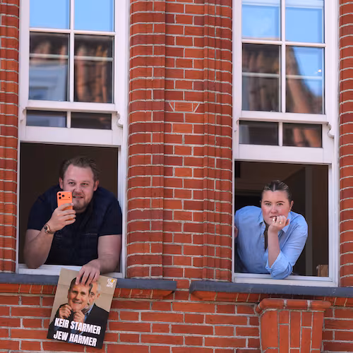 People look out of a window near the scene where two people were stabbed the previous day in the Golders Green neighbourhood, which has a large Jewish community, in London, Thursday, April 30, 2026. (AP Photo/Alastair Grant)