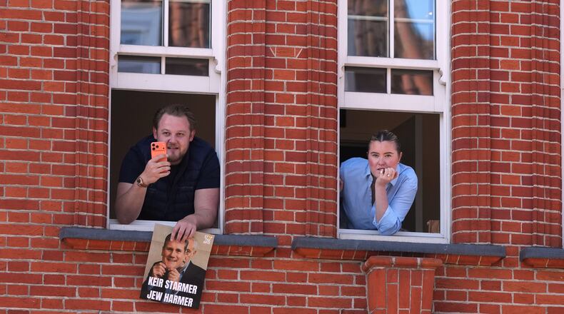 People look out of a window near the scene where two people were stabbed the previous day in the Golders Green neighbourhood, which has a large Jewish community, in London, Thursday, April 30, 2026. (AP Photo/Alastair Grant)