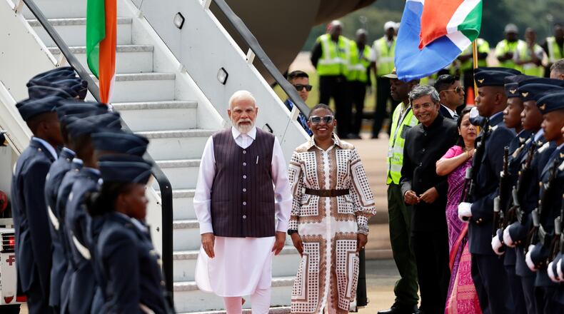 Indian Prime Minister Narendra Modi, left, is welcomed by Khumbudzo Ntshavheni, Minister in the Presidency on his arrival at the Air Force Base Waterkloof, near Pretoria, South Africa, Friday Nov. 21, 2025, ahead of the G20 Summit. (Kim Ludbrook/Pool Photo via AP)