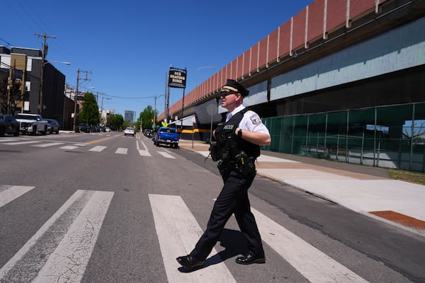 Philadelphia police captain Louis Higginson crosses a street after placing advisory flyers on automobiles, on April 28, 2025, in Philadelphia. (AP Photo/Matt Slocum)