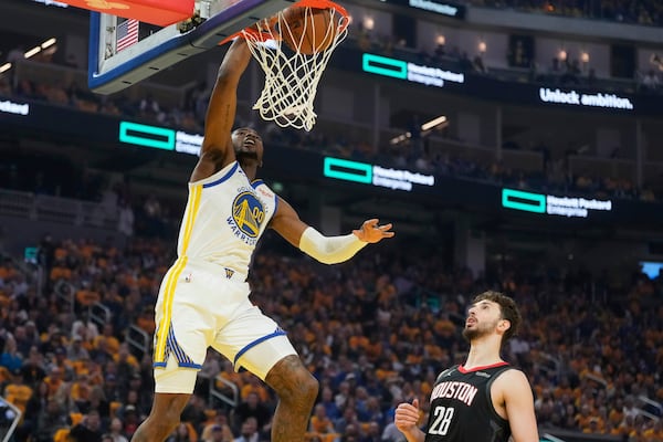 Golden State Warriors forward Jonathan Kuminga (00) dunks over Houston Rockets center Alperen Sengun (28) during the first half of Game 3 of an NBA basketball first-round playoff series in San Francisco, Saturday, April 26, 2025. (AP Photo/Jeff Chiu)