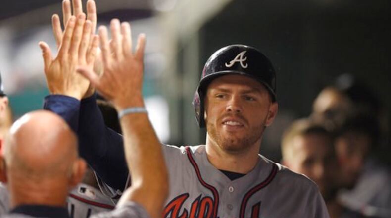 Freddie Freeman is congratulated after scoring in the seventh inning of Thursday’s 5-2 win against the Nationals. He had two doubles in that game and drove in three runs with two hits including a homer in Friday’s 5-4 loss to the Nationals. (AP Photo/Nick Wass)