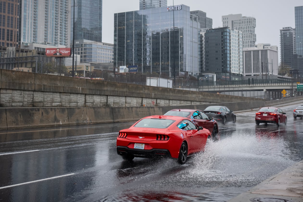 Vehicles drive through a flooded section of Techwood Drive in downtown Atlanta on Tuesday, Nov. 25, 2025. A cold front is pushing the storms across the state. (Ben Hendren for the AJC)