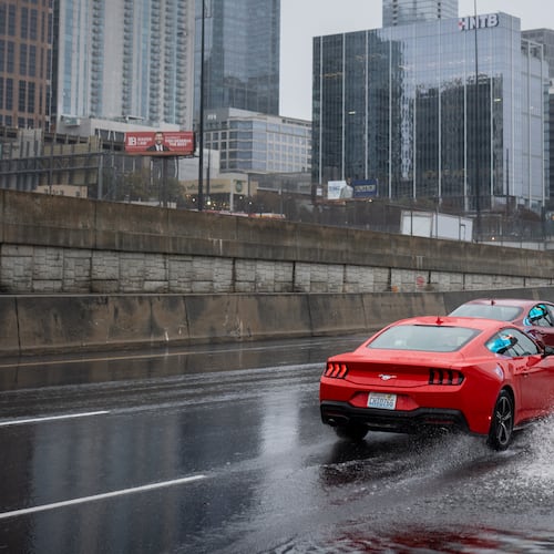 Vehicles drive through a flooded section of Techwood Drive in downtown Atlanta on Tuesday, Nov. 25, 2025. (Ben Hendren for the AJC)