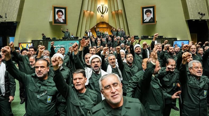 In this handout photo released by the Islamic Consultative Assembly News Agency (ICANA) Iranian lawmakers chant slogans as they wear the Revolutionary Guard's uniform in a session of parliament, in Tehran, Iran, Sunday, Feb. 1, 2026. (Hamed Malekpour/ICANA via AP)