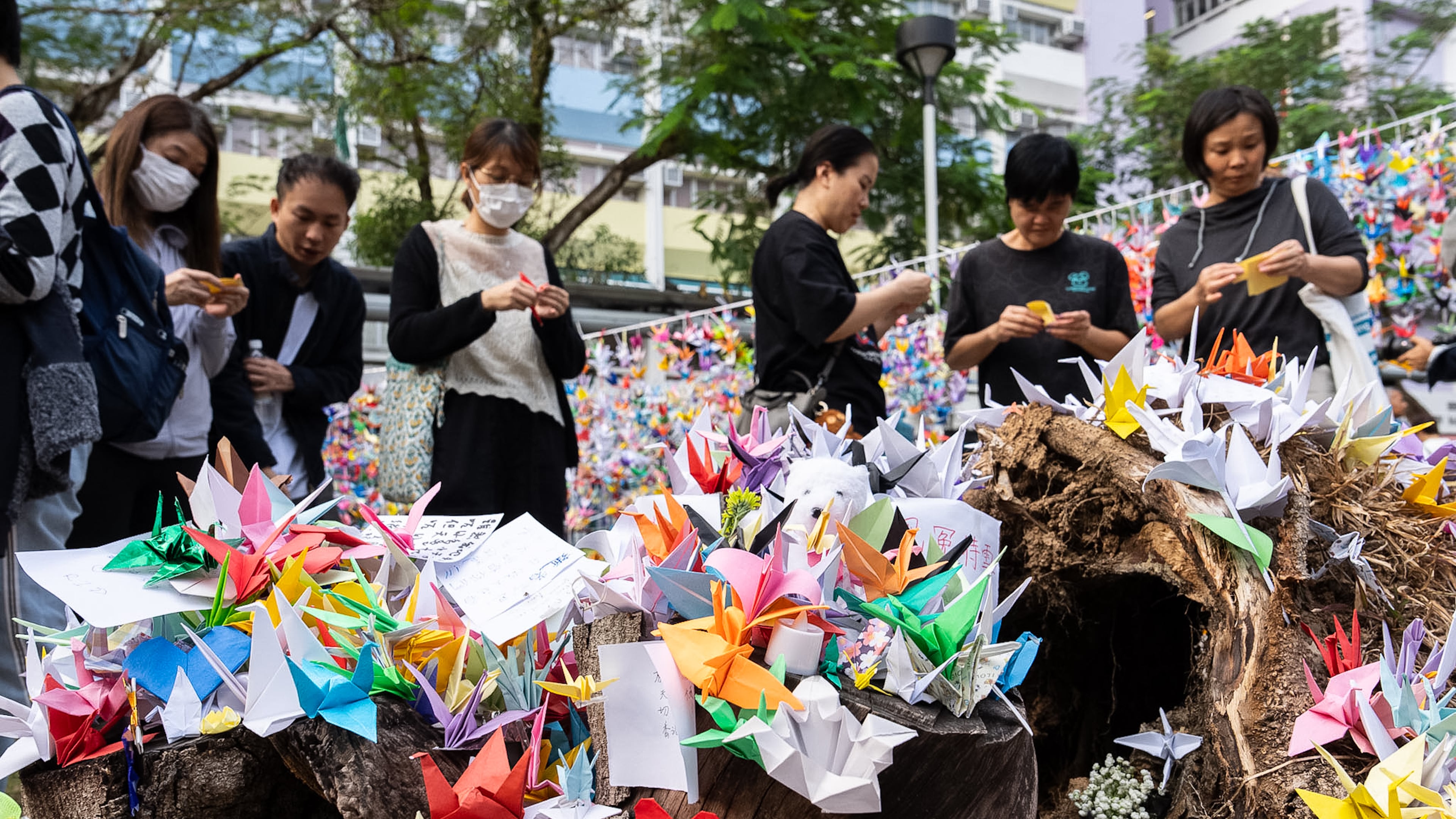 People place paper cranes near the site of the fire at Wang Fuk Court, a residential estate in the Tai Po district of Hong Kong's New Territories on Wednesday, Dec 3, 2025. (AP Photo/Chan Long Hei)