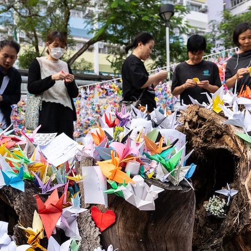 People place paper cranes near the site of the fire at Wang Fuk Court, a residential estate in the Tai Po district of Hong Kong's New Territories on Wednesday, Dec 3, 2025. (AP Photo/Chan Long Hei)