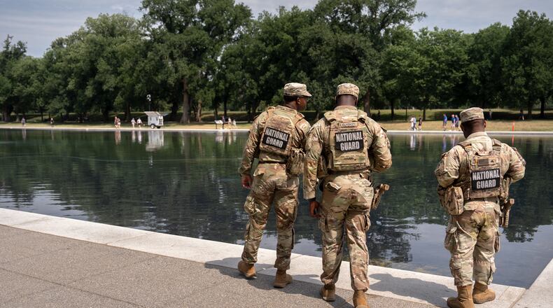 National Guard members look at the Lincoln Memorial Reflecting Pool, Monday, June 22, 2026, in Washington. (AP Photo/Mark Schiefelbein)