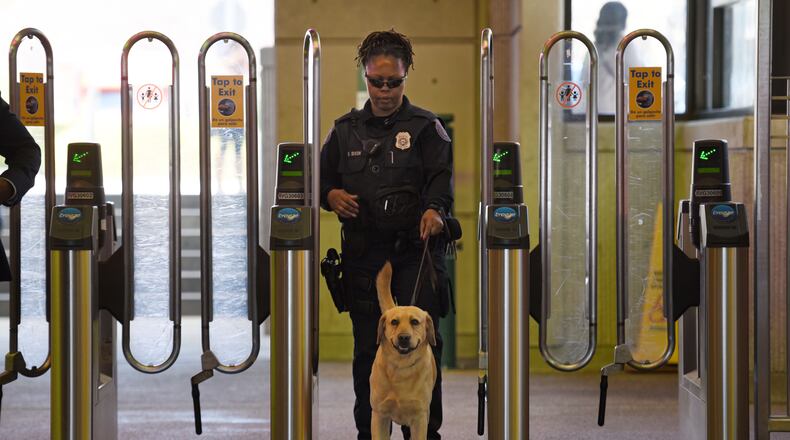 MARTA police K-9 handler Deidre Dixon guides her K-9 dog at the Lindbergh Center MARTA station in a file photo.