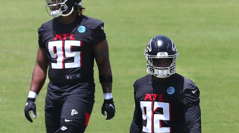 Falcons defensive lineman Ta’Quon Graham (left) and outside linebacker Ade Ogundeji (right) loosen up during rookie minicamp on Friday, May 14, 2021, in Flowery Branch. “Curtis Compton / Curtis.Compton@ajc.com”