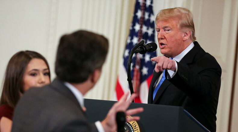 A White House staff member, left, tries to take away the microphone from CNN White House correspondent Jim Acosta during an exchange with President Donald Trump on Wednesday, Nov. 7, 2018, in Washington, D.C. (Oliver Contreras/Sipa USA/TNS)
