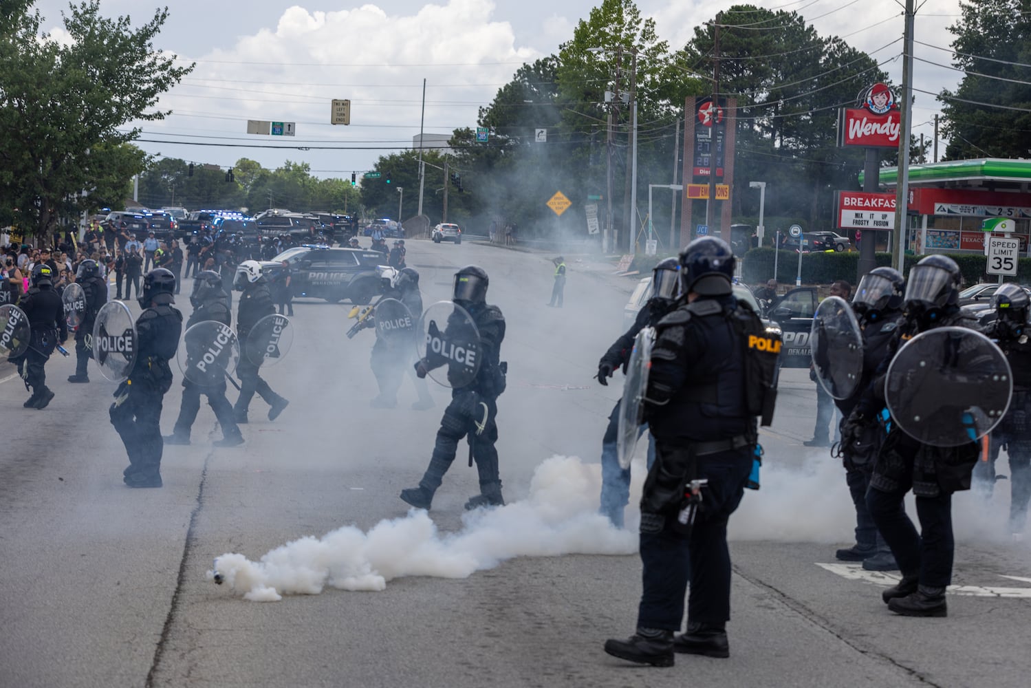Police walk through tear gas during a protest on ICE raids and deportation arrests on Chamblee Tucker Road in Atlanta on Saturday, June 14, 2025. (Arvin Temkar / AJC)