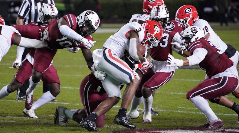 Georgia running back Zamir White (3) carries the ball against South Carolina defensive back Rodricus Fitten (10) and Damani Staley (right) during the first half Saturday, Nov. 28, 2020, in Columbia, S.C. Georgia won 45-16. (Sean Rayford/AP)