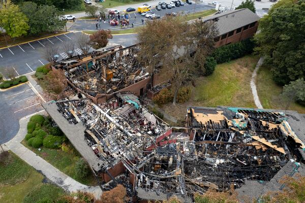 After the fire, most of the roof of the Prayer City Eagles Chapel International Ministries in Austell is gone, with wood planks hanging from the walls and the flooring covered in black ash. (Ben Gray for the AJC)